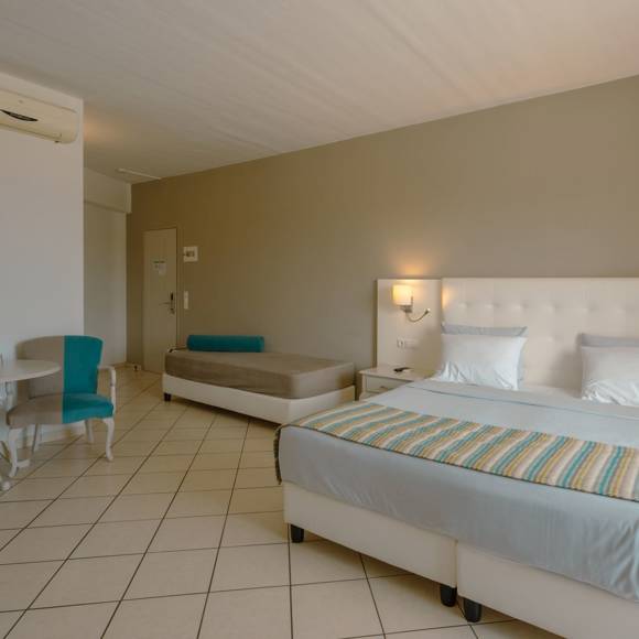 Quadruple room featuring a double bed, single beds and a seating area
