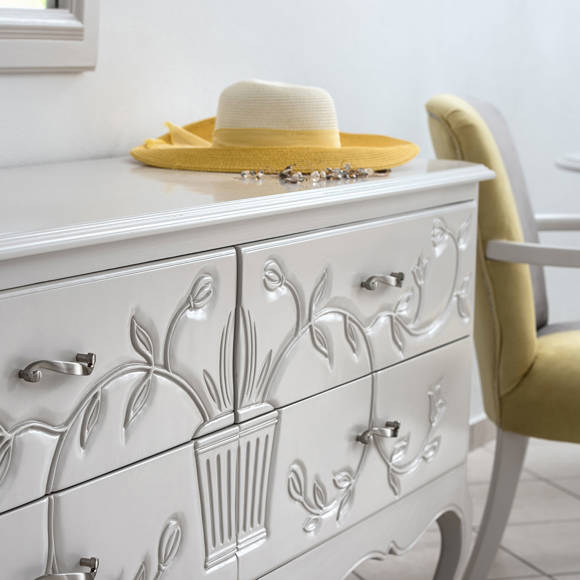 Decorative dresser with floral carvings, sunhat, and jewelry 