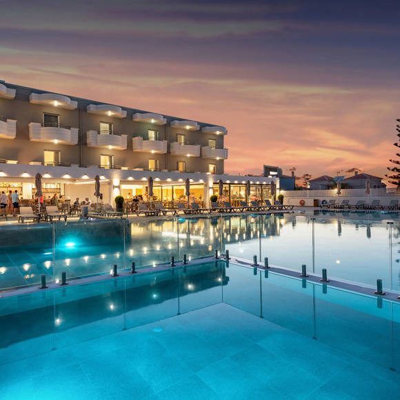 Dusk view of Dore Hotel with illuminated pool and restaurant terrace