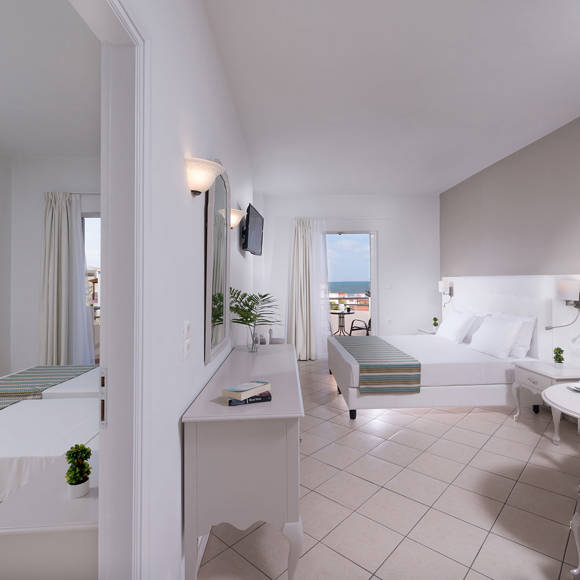 Wide view of the two bedroom family room, featuring a main double bed and a separate area with twin beds.