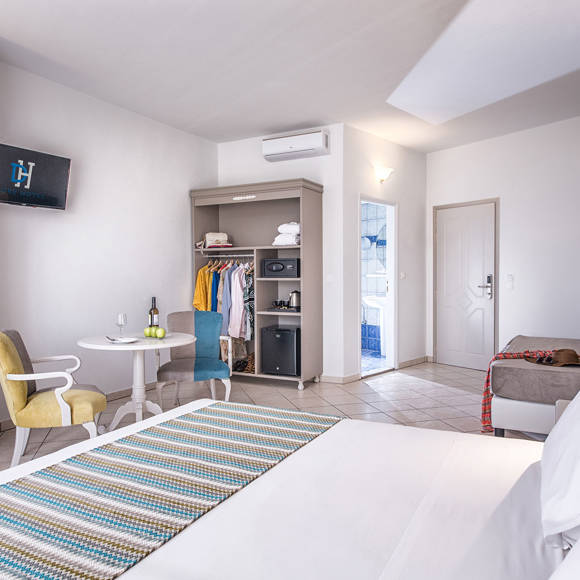 Double room with sitting area, open wardrobe, and view of the entrance and bathroom