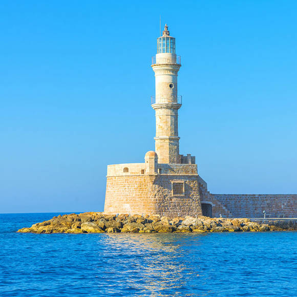 Chania's iconic lighthouse in the Venetian harbor, surrounded by calm blue sea