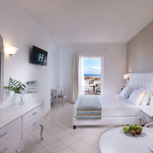 Family room with double bed, mirror dresser and balcony overlooking the sea