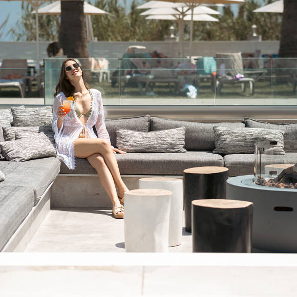 Woman relaxing with a cocktail on the hotel's outdoor firepit sitting area