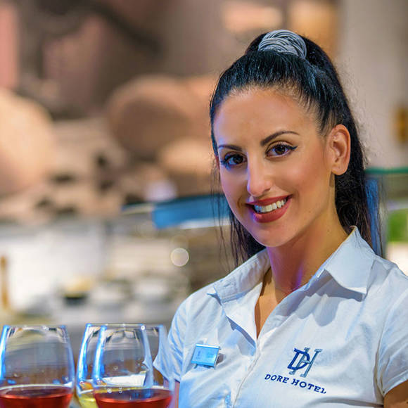 Waitress in Dore Hotel Restaurant holding a tray with glasses of wine