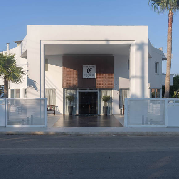Dore Hotel modern entrance with large white geometric arch and glass double doors